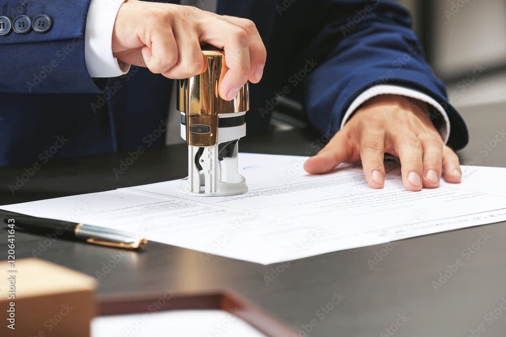 Un homme qui met un cachet sur une feuille