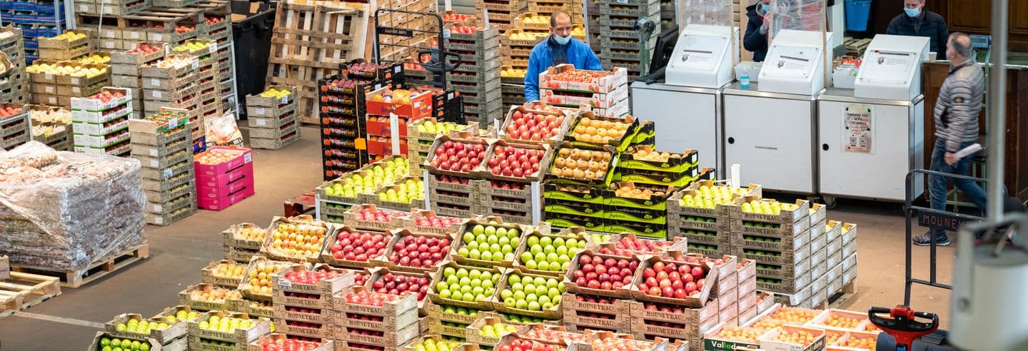 Cagettes de fruits et légumes empilées dans le pavillon du Marché de Rungis