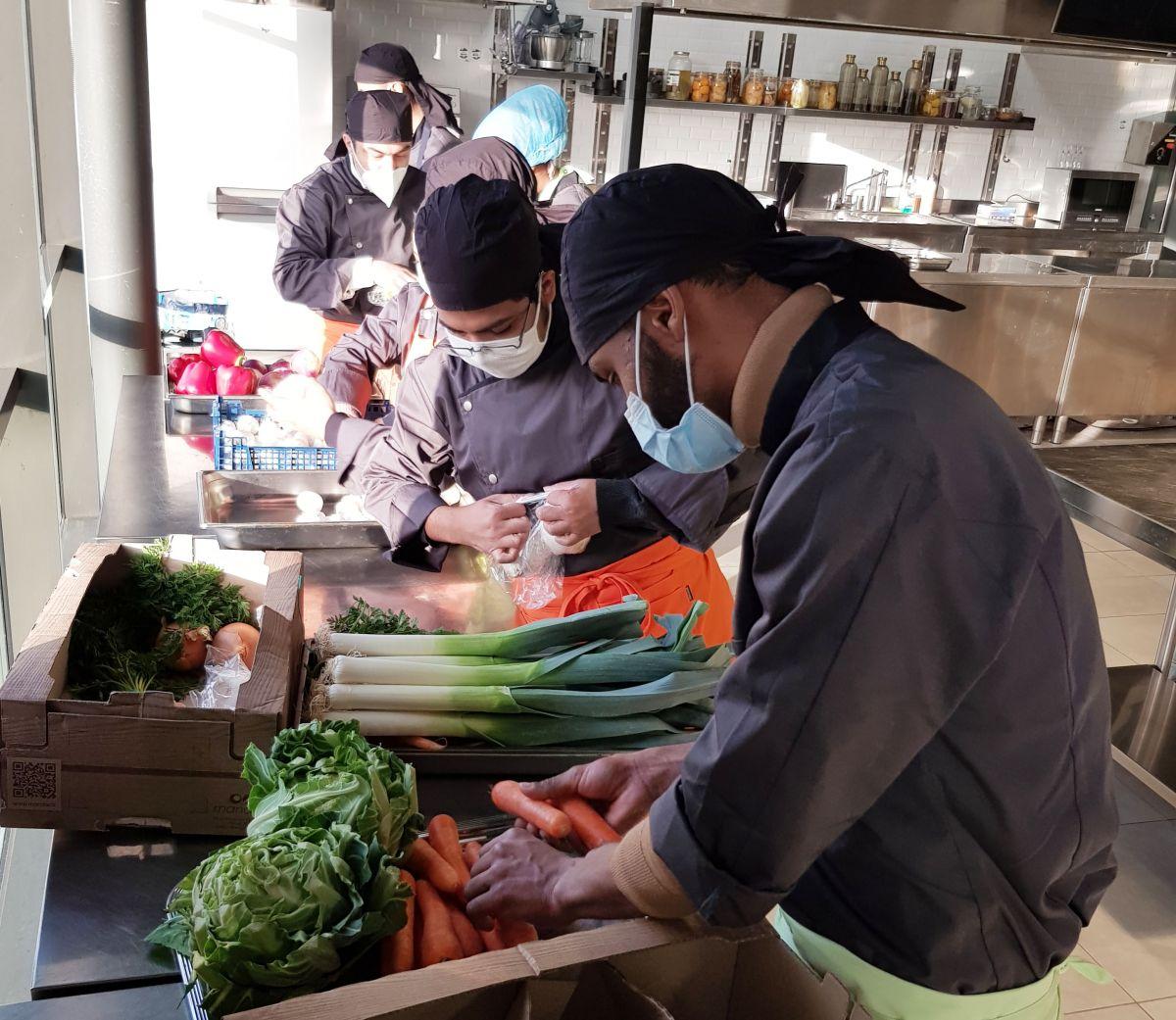 Apprentis en formation qui apprennent à couper des légumes sur le Marché de Rungis