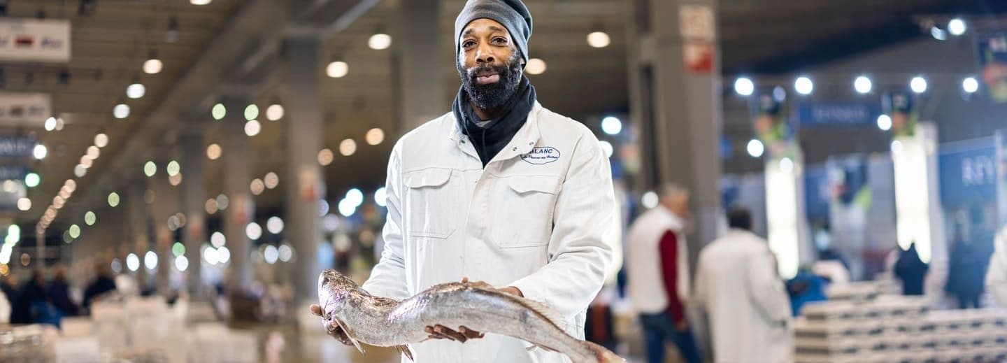 Grossiste tenant un poisson dans ses mains